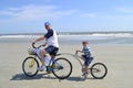 Father and son on alley cat bike at the beach