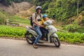 Father and son are traveling on a moped on a tea plantation in Malaysia. Traveling with children concept Royalty Free Stock Photo