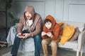 Father and son tween boy in hoodies playing computer games with joystick at home tipical caucasian family Royalty Free Stock Photo