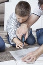 Father and son twist furniture. The boy is holding a screwdriver and the father helps to screw the screw.