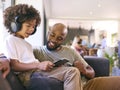 Father And Son Using Digital Tablet With Headphones At Home With Multi-Generation Family Behind Royalty Free Stock Photo