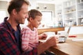 Father and son using laptop computer at home Royalty Free Stock Photo