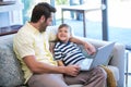 Father and son using laptop on the couch Royalty Free Stock Photo