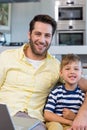 Father and son using laptop on the couch Royalty Free Stock Photo