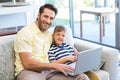 Father and son using laptop on the couch Royalty Free Stock Photo