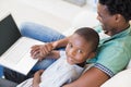 Father and son using laptop on the couch Royalty Free Stock Photo