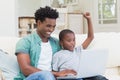 Father and son using laptop on the couch Royalty Free Stock Photo