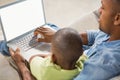 Father and son using laptop on the couch Royalty Free Stock Photo