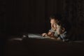 Father and son using laptop by night at home on the bedroom Royalty Free Stock Photo