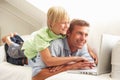 Father And Son Using Laptop Sitting On Sofa Royalty Free Stock Photo