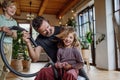 Father and son vacuuming girl& x27;s hair with vacuum cleaner. Father with kids cleaning house, helping with house chores