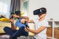 Father and son in virtual reality headsets playing with joysticks at home Royalty Free Stock Photo