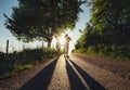 Father with son walk together on sunset road