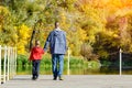 Father and son are walking along the pier. Autumn, sunny. Back v Royalty Free Stock Photo