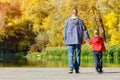 Father and son are walking along the pier. Autumn, sunny. Back v Royalty Free Stock Photo