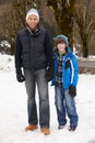 Father And Son Walking Along Snowy Street