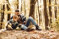 Father and son walking in autumn forest at sunset. Sweetheart child and bearded dad lie on fall autumnal yellow leaves Royalty Free Stock Photo