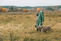 Father and son walking in a field with a dog