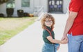 Father and son walking trough school park. Portrait of happy nerd pupil holding teachers hand. Royalty Free Stock Photo