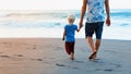 Father and son walks on sunset ocean beach Royalty Free Stock Photo