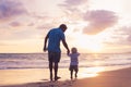 Father and son wallking on the beach