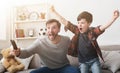 Father and son watching football on TV at home. Royalty Free Stock Photo