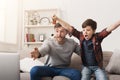 Father and son watching football on TV at home Royalty Free Stock Photo