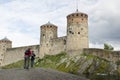 Father and son watching and taking a picture of olavinlinna castle