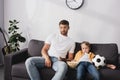 Father and son watching tv while Royalty Free Stock Photo