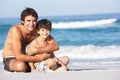 Father And Son Wearing Swimwear Sitting Down