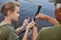 Father and son on wood pontoon, dad teaching his young son to untangle knot on fishing line, family spending time together while Royalty Free Stock Photo