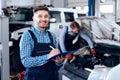 Father and son work at the auto service. Two mechanics work with the details of the car. Royalty Free Stock Photo