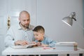 Father and son work together on school homework or homeschooling. Royalty Free Stock Photo