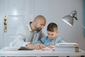 Father and son work together on school homework or homeschooling. Royalty Free Stock Photo