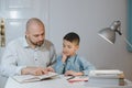 Father and son work together on school homework or homeschooling. Royalty Free Stock Photo