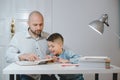 Father and son work together on school homework or homeschooling. Royalty Free Stock Photo