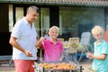 Father with sons grilling meat in the garden Royalty Free Stock Photo