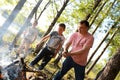 Father with sons lighting bonfire in forest