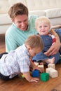 Father And Sons Playing With Coloured Blocks At Ho