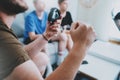 Father and sons sitting on a sofa in living room and playing video games. Family relaxing time at home concept. Closeup. Royalty Free Stock Photo