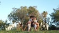 Father squats in the park and hugs his two sons. Happy family concept