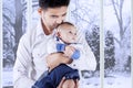 Father standing at home while holding his son Royalty Free Stock Photo