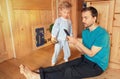 Father stay at home with little son. Lifestyle photo of dad and child video chatting on smartphone in living room. Stay connected