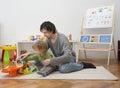 Father and sweet little child boy having fun playing with cars and colorful toys, on the floor, at home. Beautiful family moment, Royalty Free Stock Photo