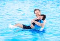 Father swimming in pool with disabled child