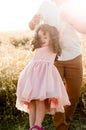 Father swinging a little girl with curly hair in pink dress Royalty Free Stock Photo