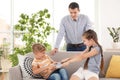 Father taking tablet from fighting children