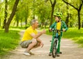 Father talking with his son riding a bicycle and showing thumbs up Royalty Free Stock Photo