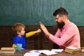 Father teacher and cute child pupil playing in classroom. Schoolboy achieving the task. Little champion salutation.