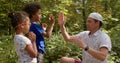 Father teaches children playing with hands. Lifestyle, outdoor. Patty Cake game. Royalty Free Stock Photo